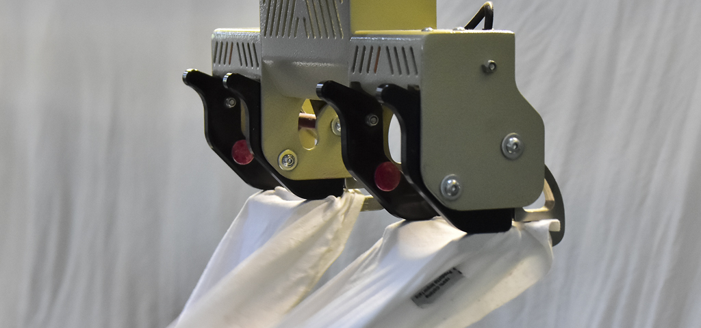 Automatic clamp feeder stations gripping linen