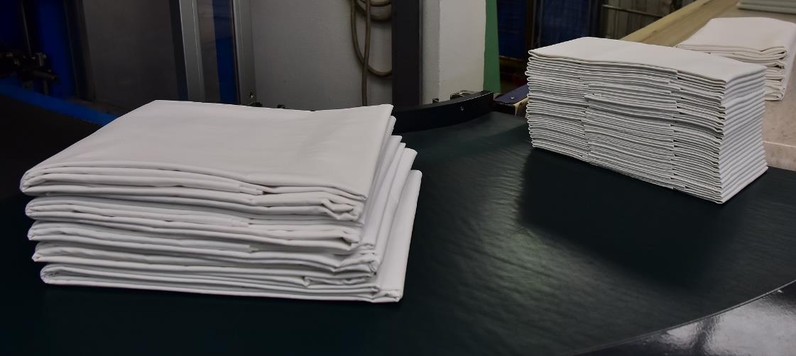 Folded linen stacked at the end of the finishing line